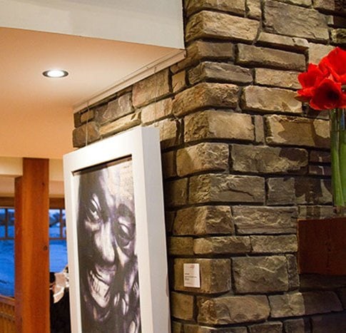 picture-hanging-system-stone-stone-wall-artiteq-hang-logic print of jazz singer hung on stone wall with Artiteq picture hanging system