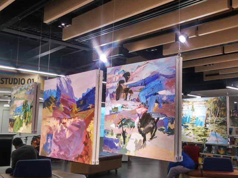 Paintings hanging from a wooden beam