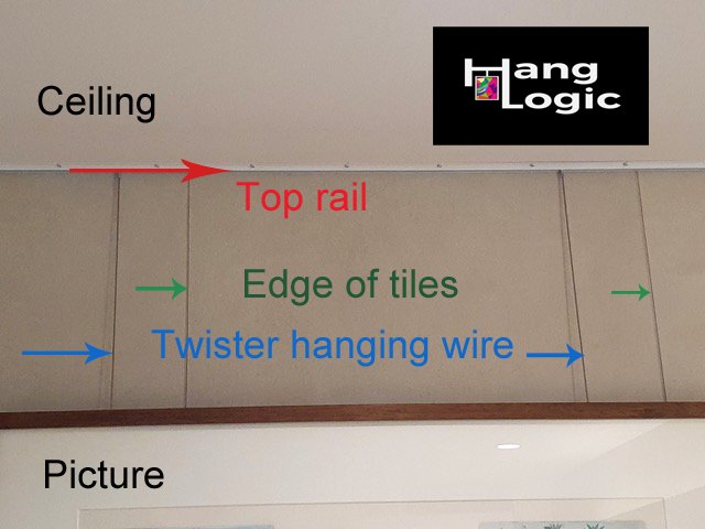 Picture hanging system attached to ceiling above tiled wall